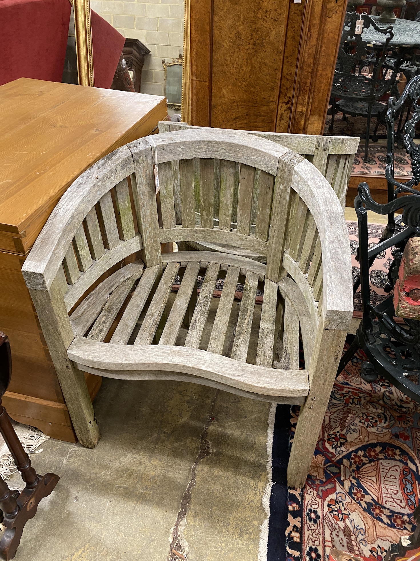 A pair of weathered teak tub shaped garden elbow chairs, width 67cm, depth 49cm, height 85cm